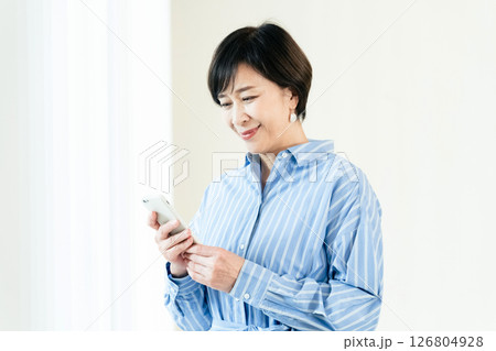 スマホを操作する中高年女性 126804928