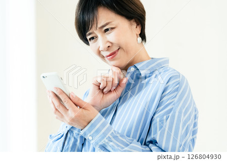 スマホを操作する中高年女性 126804930
