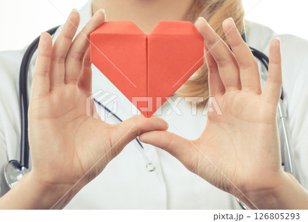 Hand of doctor holding red heart made of paper. Health care and treatment Hand of doctor holding red heart made of paper. Health care and treatment 126805293