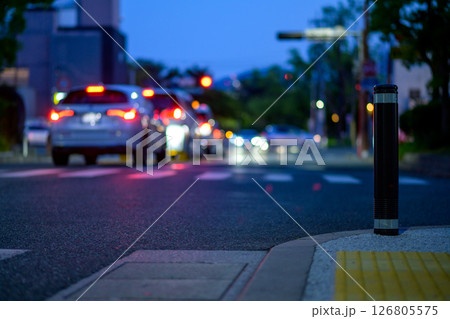 歩道の車止めと車で混み合う夜間交差点　ボラード 126805575