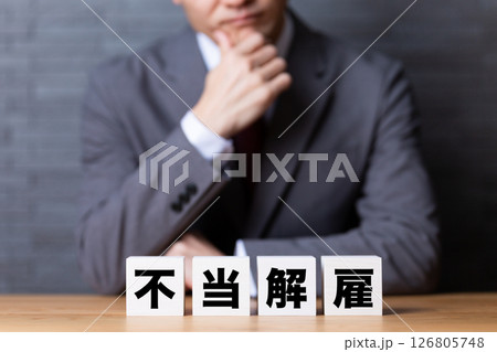 不当解雇のブロックとスーツを着て悩むミドル男性ビジネスマン 不当解雇のブロックとスーツを着て悩むミドル男性ビジネスマン 126805748
