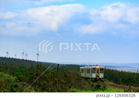 陸奥湾と風力発電機を背景に下北半島の海岸線を走る大湊線 126806326