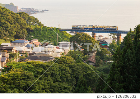 雄大な日本海が広がる詩情あふれる夕景を背景に五能線の気動車が走る 雄大な日本海が広がる詩情あふれる夕景を背景に五能線の気動車が走る 126806332