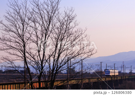 朝日に照らされた富山地方鉄道が常願寺川を渡る 126806380
