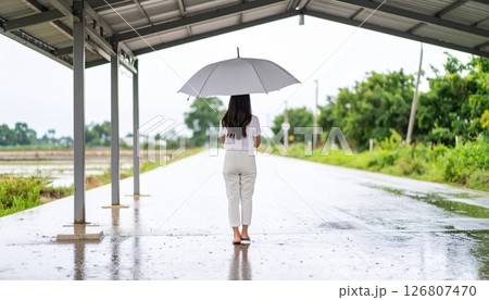 雨宿りをする女性　屋根の下に避難している女性 126807470