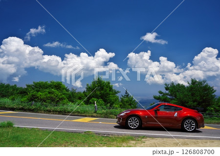 初夏の青山高原　白い雲と青空の下でドライブする赤いフェアレディZ 126808700