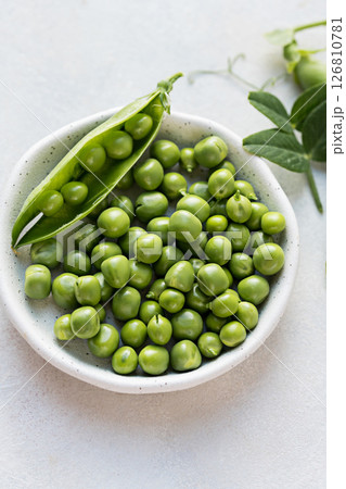 Close-up fresh green peas beans in a white plate. Macro photography Close-up fresh green peas beans in a white plate. Macro photography 126810781