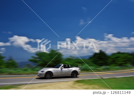 初夏の青山高原 白い雲と青空の下でドライブするマツダのオープンカー 初夏の青山高原 白い雲と青空の下でドライブするマツダのオープンカー 126811149