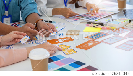 Collaborative Design Session. Team brainstorming with UI UX prototypes and color palettes. 126811345