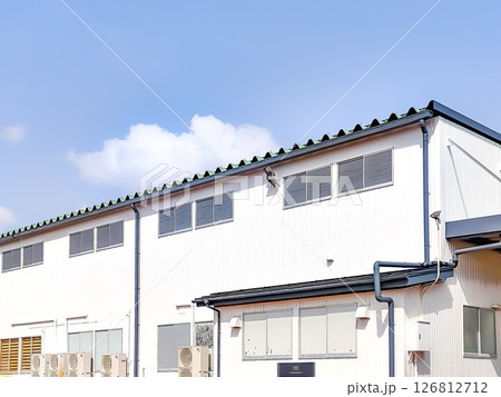 白い外壁の工場と青空 126812712