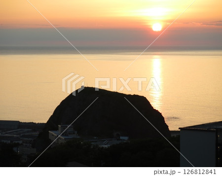 ウトロ温泉の高台にあるリゾートホテルから見たオホーツク海の夕日とオロンコ岩 126812841