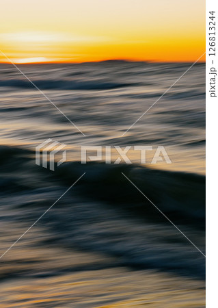 blurry photo of ocean against a sunset background. beauty in nature.  126813244