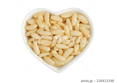 Shelled European pine nuts in ceramic bowl isolated on white background with full depth of field. Top view. Flat lay 126813298