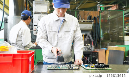 工場でハンディターミナルを使って製品を検査する男性作業員 126813613