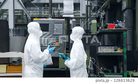 防護服を着て工場の中で話す男女作業員 126813629