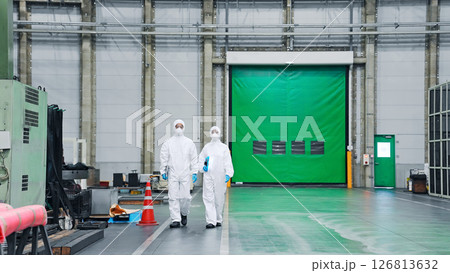 防護服を着て工場の中を歩く男女作業員 防護服を着て工場の中を歩く男女作業員 126813632