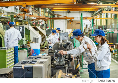 工場で工作機械を操作する作業員グループ 126813670