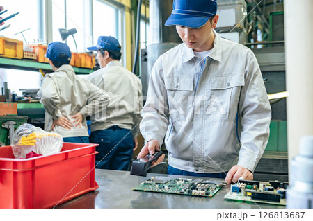 工場でハンディターミナルを使って製品を検査する男性作業員 126813687