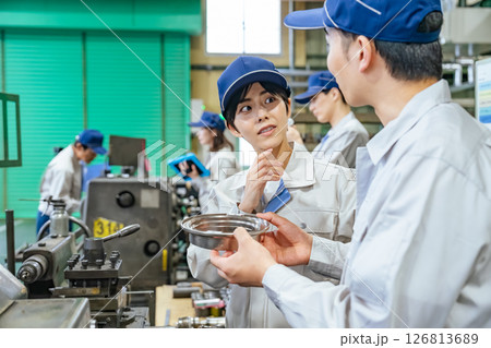 工場で工作機械を操作する作業員グループ 126813689