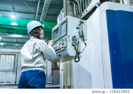操作盤で工場機械を操作する女性作業員 操作盤で工場機械を操作する女性作業員 126813691
