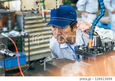 工場で機械を操作する男性作業員 126813699