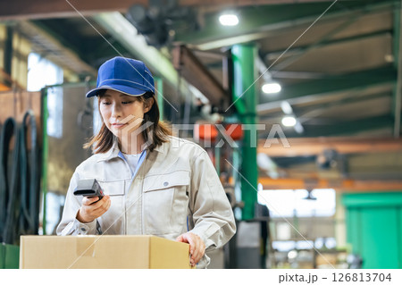 工場でハンディターミナルを使って商品を管理する女性作業員グループ 126813704