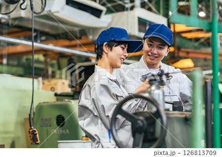 工場で機械を操作する作業員グループ 126813709