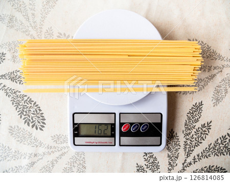 top view of dry pasta is weighed on kitchen scale 126814085