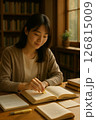 図書室で参考書に付箋を貼って学ぶ大学院生 126815009