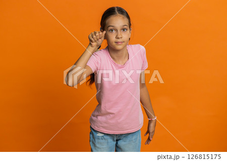Confused child girl kid knocking door gesture asking who is at home, feeling embarrassed, no idea 126815175