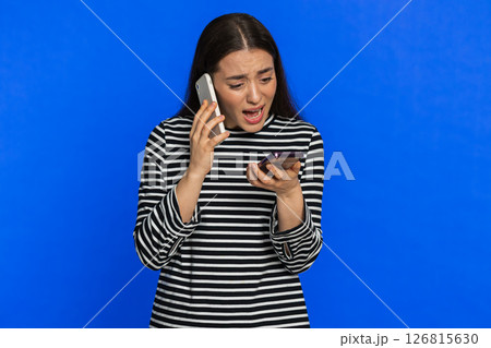 Irritated stressed business woman talking on two mobile phones having conversation conflict quarrel Irritated stressed business woman talking on two mobile phones having conversation conflict quarrel 126815630
