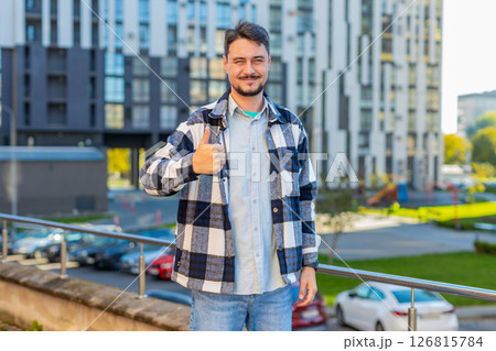 Happy mature Caucasian man showing thumb up gives positive reply standing on downtown city street Happy mature Caucasian man showing thumb up gives positive reply standing on downtown city street 126815784