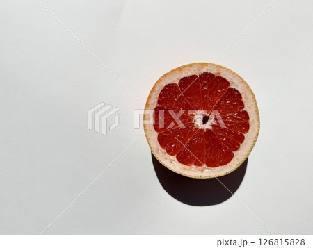 juicy bright red grapefruit cut into two parts on a white background. High quality photo juicy bright red grapefruit cut into two parts on a white background. High quality photo 126815828