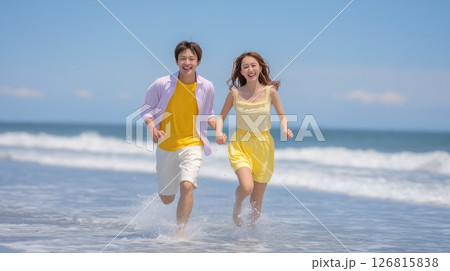 夏のビーチを手をつないで走る若いカップル 126815838