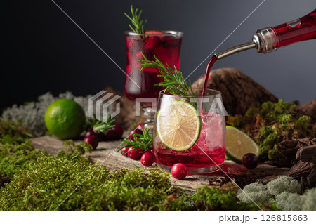 Refreshing cranberry hard seltzer with lime, rosemary, and ice. 126815863