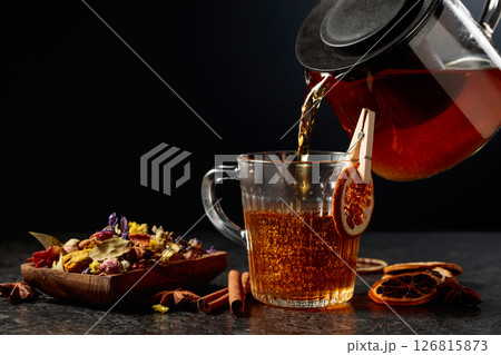 Hot herbal tea is poured into a glass mug. Hot herbal tea is poured into a glass mug. 126815873