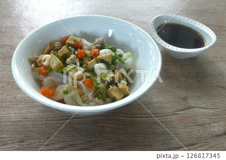 steamed large rice noodles topping chop pork and dice tofu with carrot dressing black soy sauce on plate steamed large rice noodles topping chop pork and dice tofu with carrot dressing black soy sauce on plate 126817345