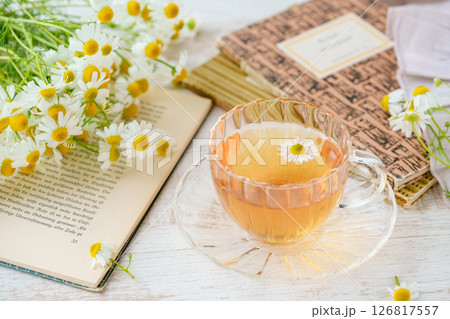 フレッシュなカモミールの花とハーブティーと洋書 126817557