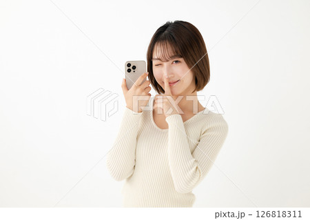 スマホを持ってウィンクする女性 スマホを持ってウィンクする女性 126818311