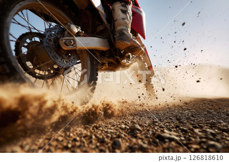 Dynamic image of rider in motion on cross bike speeding fast , leaving dust of sand behind. Dakar rally 126818610