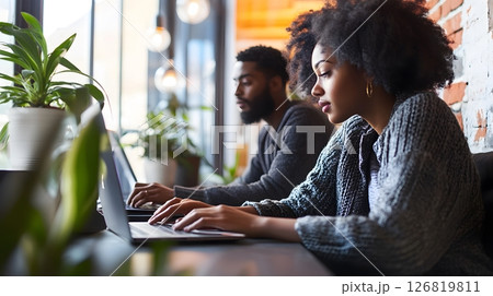 Young couple working side by side on laptops modern apartment relaxed mood everyday life Young couple working side by side on laptops modern apartment relaxed mood everyday life 126819811