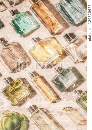 Diverse selection of perfume bottles displayed artistically against a soft textured background 126820978