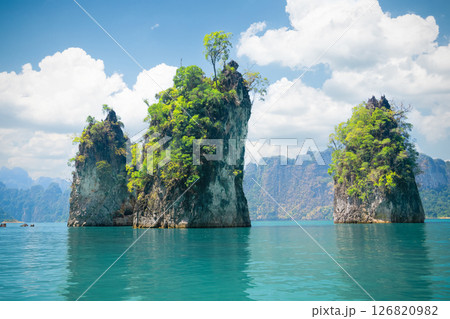 Three rocks Cheo Lan Lake under a bright blue sky and reflected in emerald turquoise waters of the lake in Khao Sok Park. Famous famous nature panoramas and tourist destinations Thailand, Thai nature 126820982
