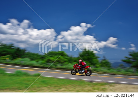 初夏の青山高原 白い雲と青空の下でツーリングする赤いバイク 初夏の青山高原 白い雲と青空の下でツーリングする赤いバイク 126821144
