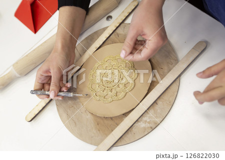 The child's hands make a clay plate. Master class on making clay products. 126822030