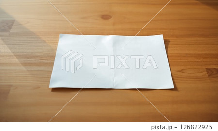 Art photo of desk with paper. Candlelight warms the wood, smooth texture. 126822925