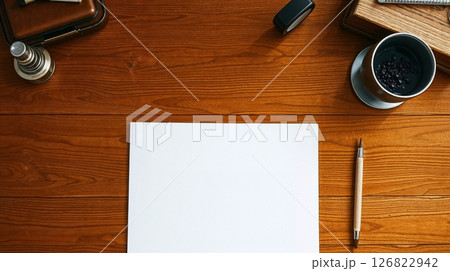 Art photo of desk with paper. Candlelight warms the wood, smooth texture. 126822942