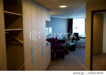 Mainz, Germany, July 7, 2017: Hotel Room Entrance with Wardrobe, Desk, and Dark Red Sofa 126823034
