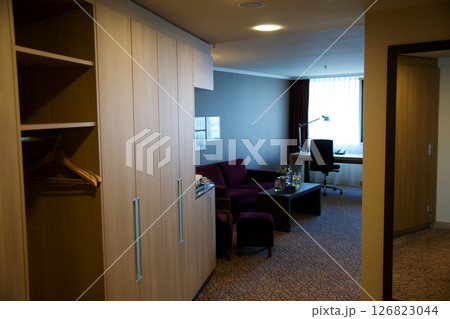 Mainz, Germany, July 7, 2017: Hotel Room Entrance with Wardrobe, Desk, and Dark Red Sofa 126823044