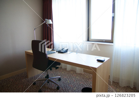 Mainz, Germany, July 7, 2017: Hotel Room Desk with Telephone, Lamp, and Chair by the Window 126823205